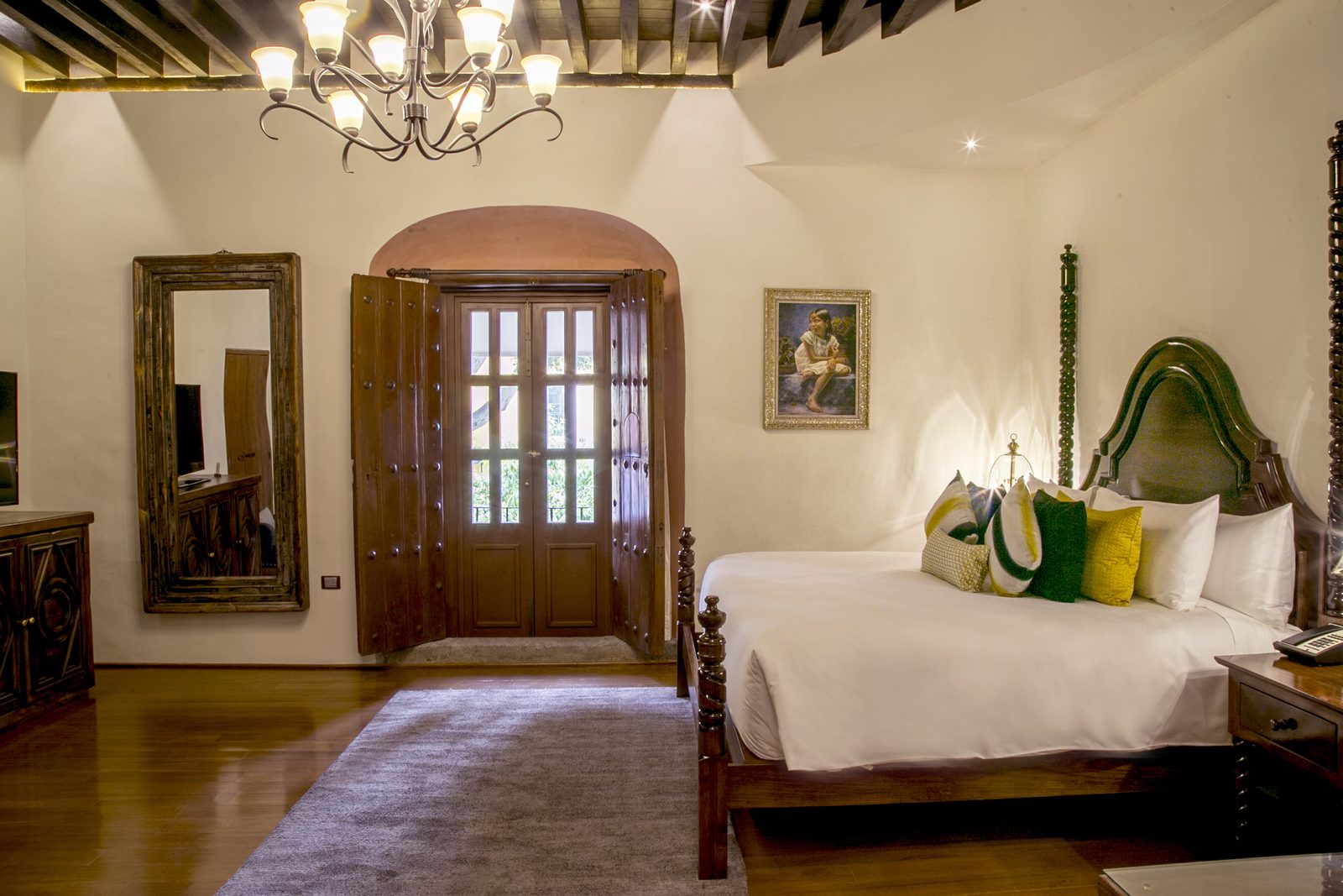 Suite Talavera con cama king y puerta de madera al balcón.